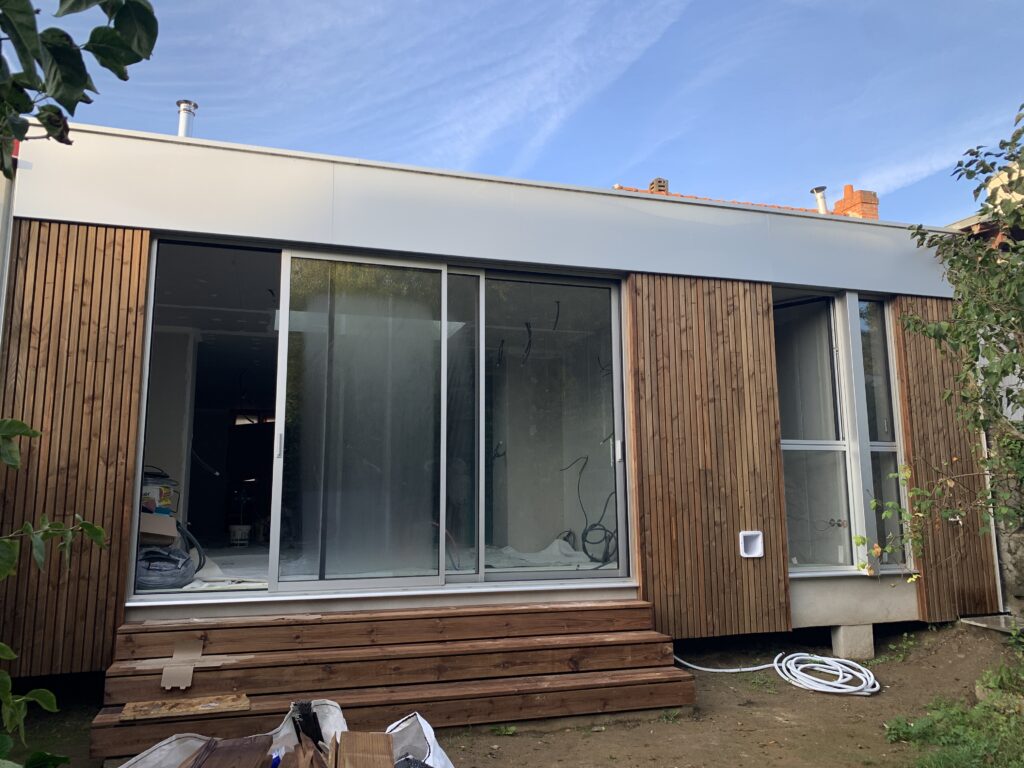 Vue après les travaux montrant la grande ouverture de mur porteur reliant la maison existante à l'extension.