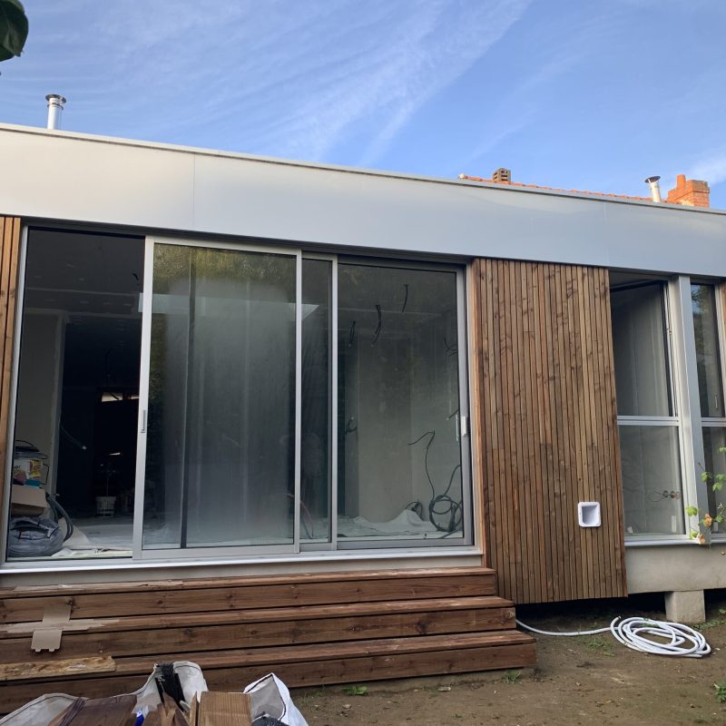 Vue après les travaux montrant la grande ouverture de mur porteur reliant la maison existante à l'extension.