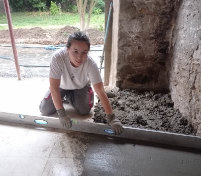 Emeline, élève ingénieure, utilise une règle de maçon sur un chantier de rénovation de l'entreprise MEYER.